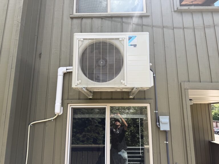 Wall-mounted Daikin outdoor mini-split unit with covered refrigerant lines