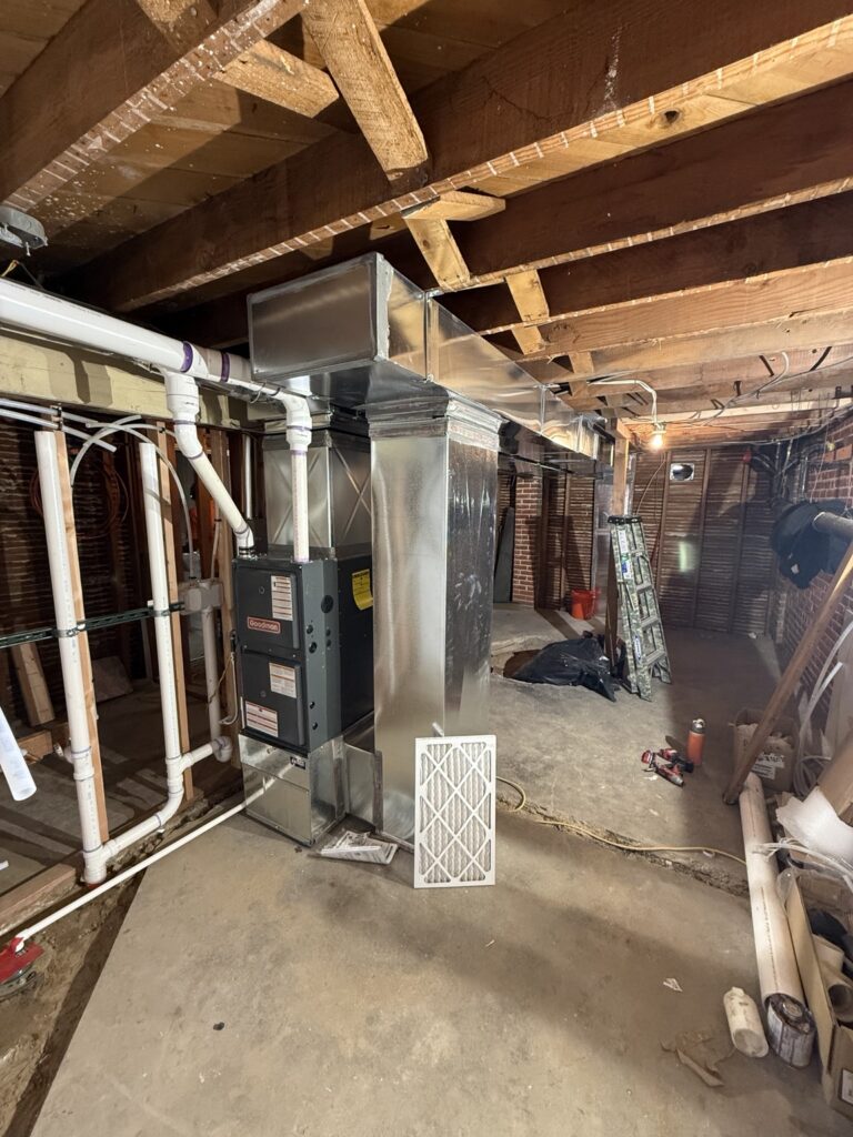 Goodman furnace with sheet-metal supply and return ductwork in a basement
